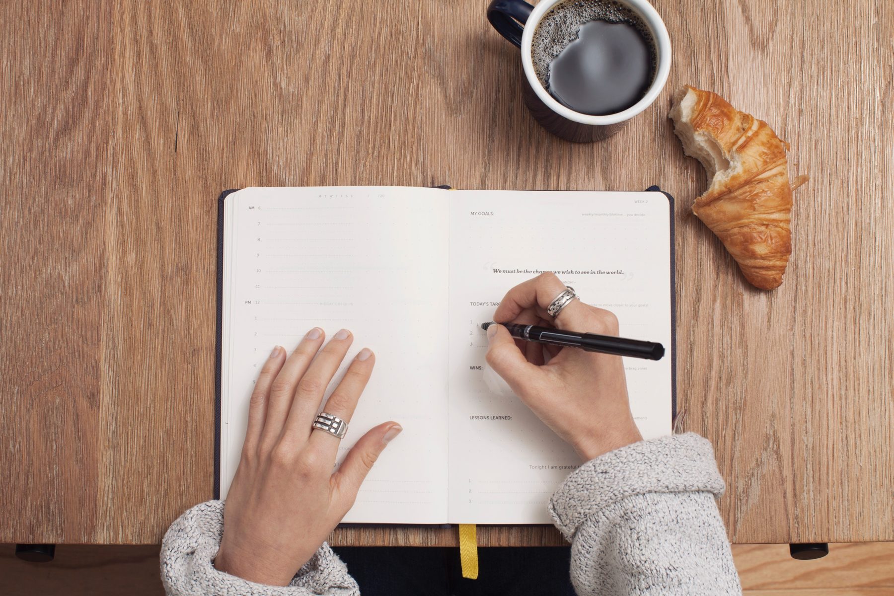 pisanie w notatniku na biurku kawa croissant